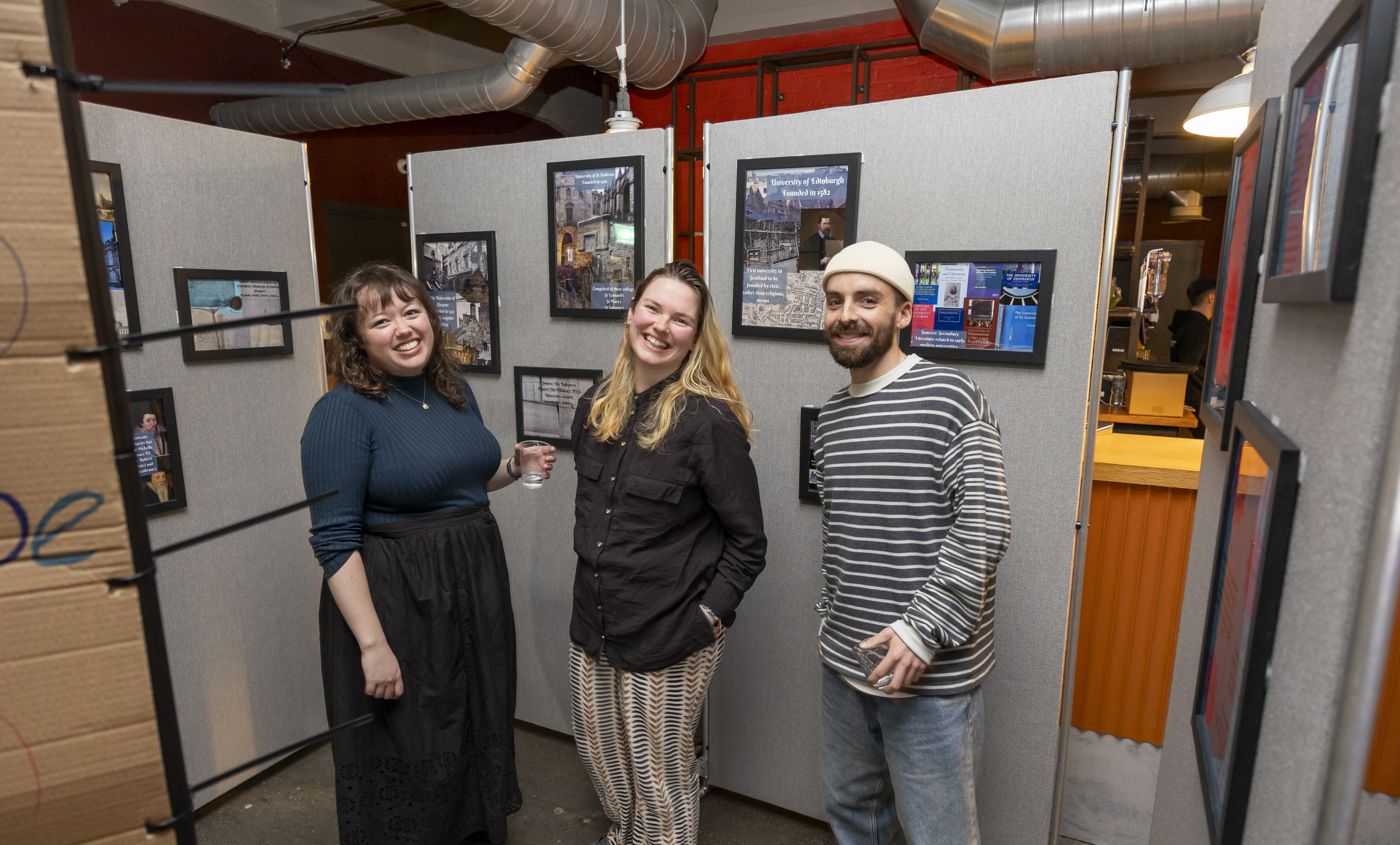 3 people smiling next to poster boards covered in pictures