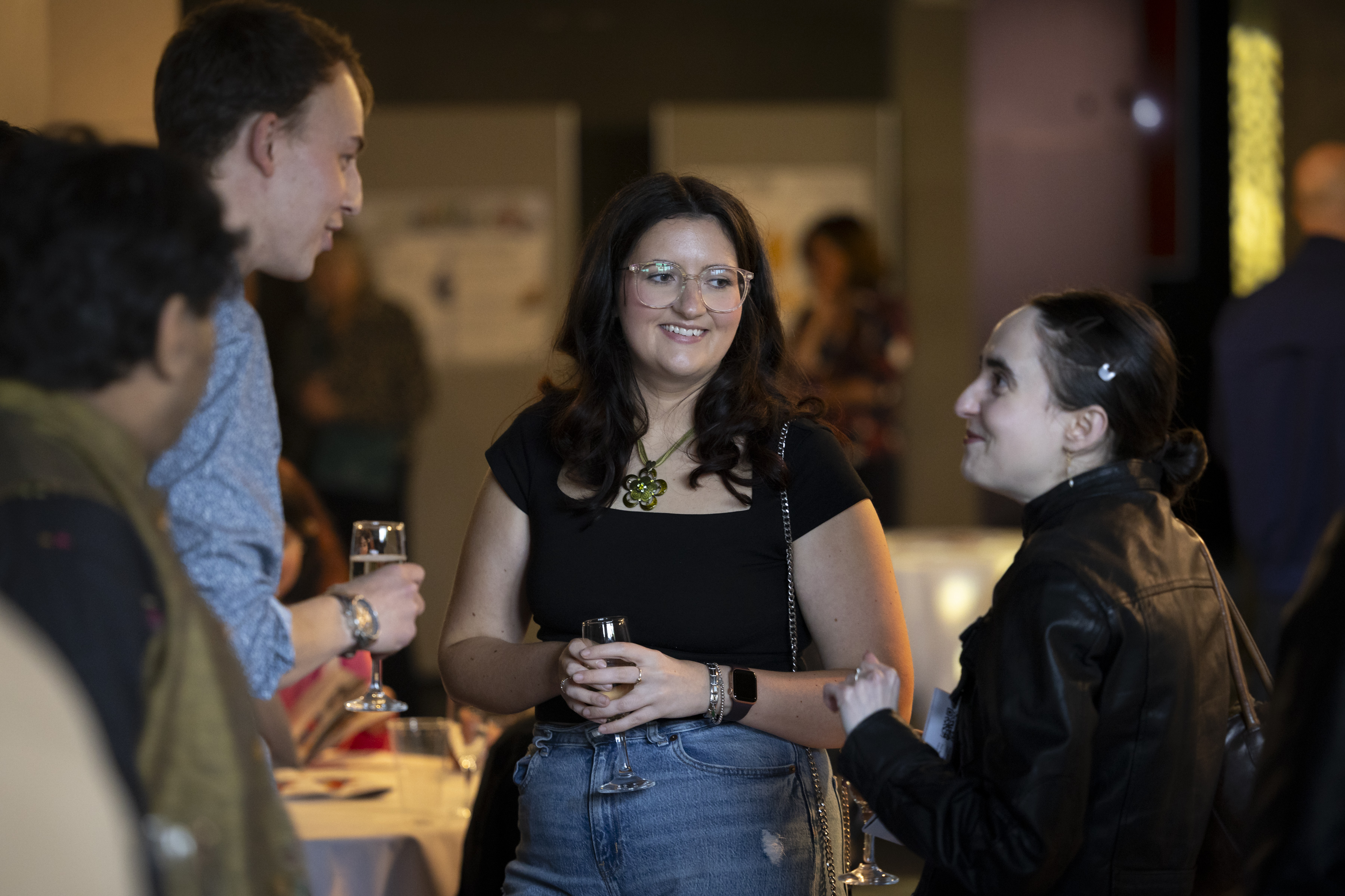 3 people mingling with drinks at an event