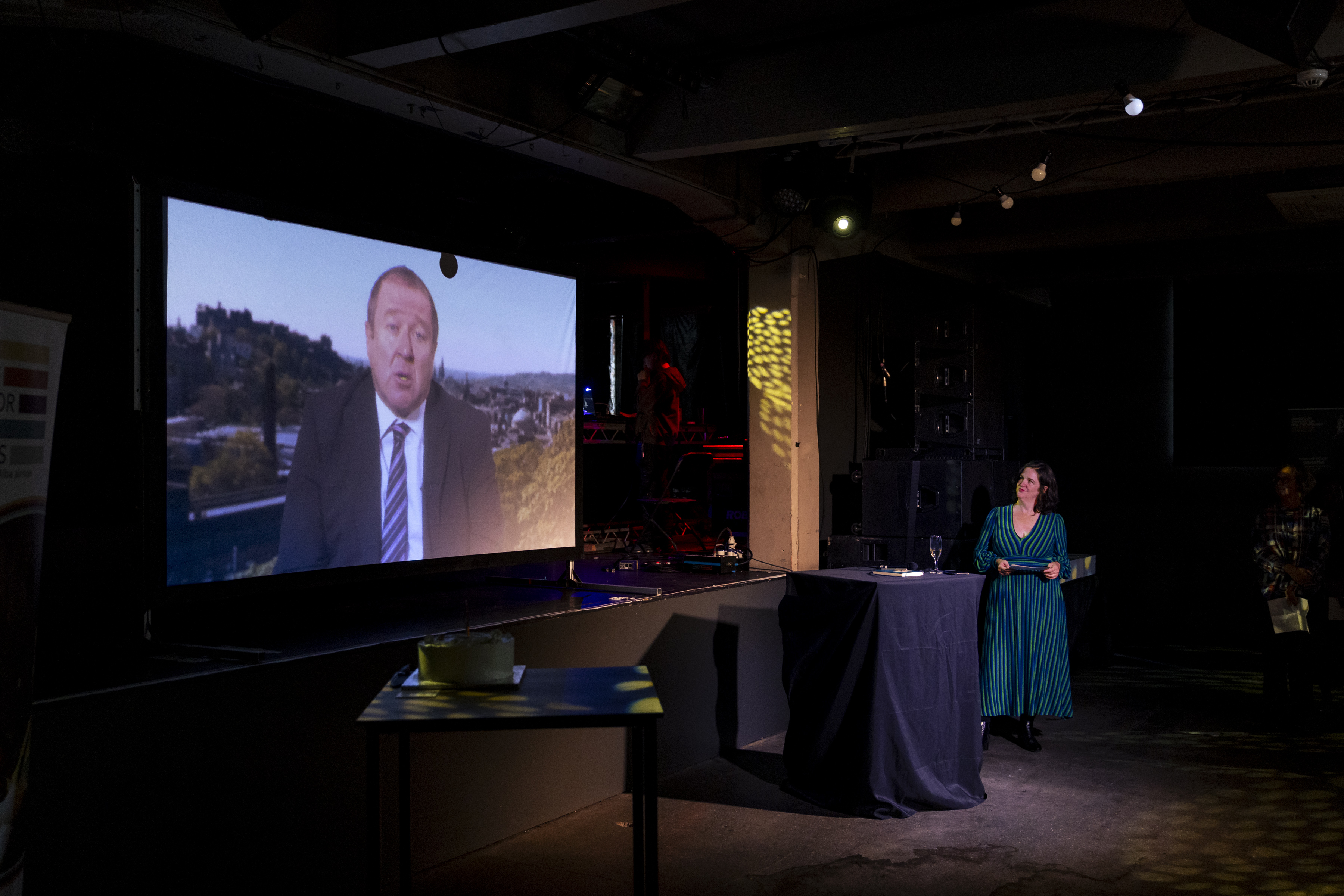 Professor Claire Squires watching a video on a projector screen